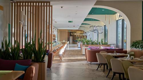 a restaurant with tables and chairs and a bar at Holiday Inn Tashkent City by IHG in Tashkent