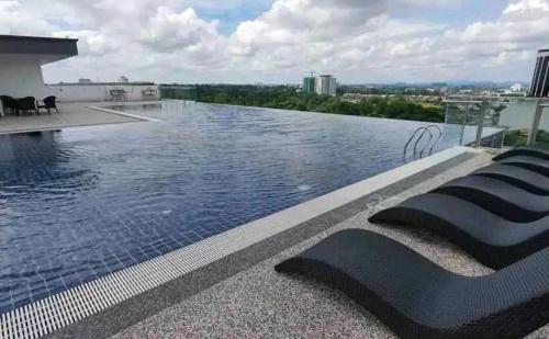 a swimming pool on the roof of a building at Astini Studio in Kuching