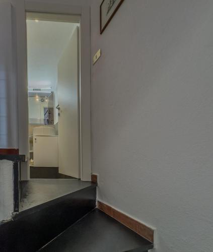 a hallway with a white wall and a door at La Maison de la Mer with Terrace and AC in Vernazza