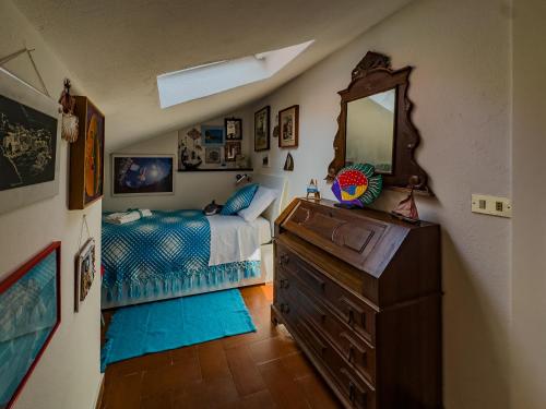 a bedroom with a bed and a dresser with a mirror at La Maison de la Mer with Terrace and AC in Vernazza