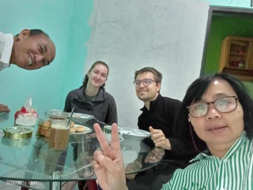 a group of people sitting around a table with food at Petra Homestay Bangka Leda in Ruteng