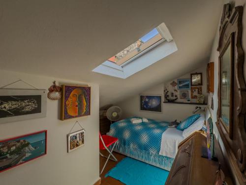 a bedroom with a bed and a skylight at La Maison de la Mer with Terrace and AC in Vernazza