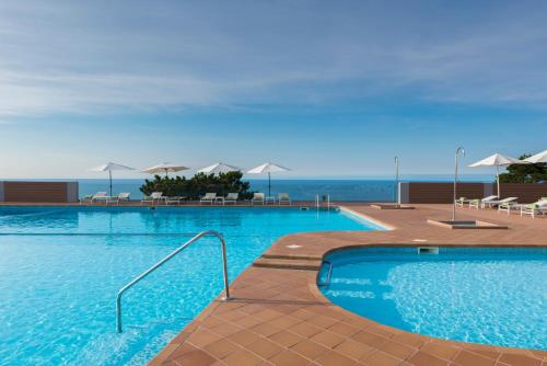 a large swimming pool with a view of the ocean at Mercure Monte Igueldo in San Sebastián