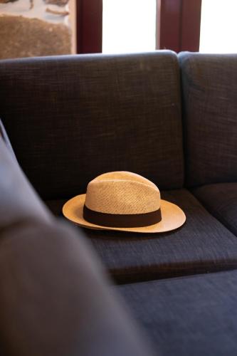 a hat sitting on top of a couch at Villa & Stone House with Pool, 10 Mins to Skala Eressos Beach in Eresos