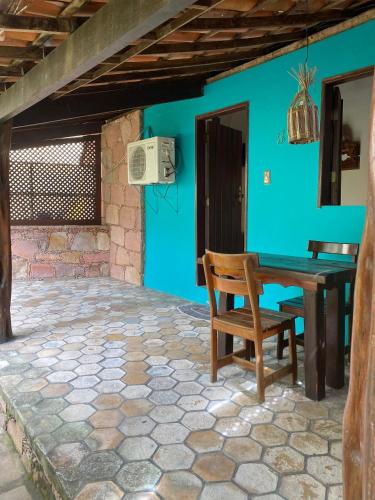 a table and a chair in front of a blue wall at Pousada e Camping Lumiar in Lençóis