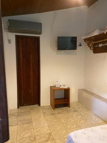 a room with a door and a television on the wall at Pousada e Camping Lumiar in Lençóis