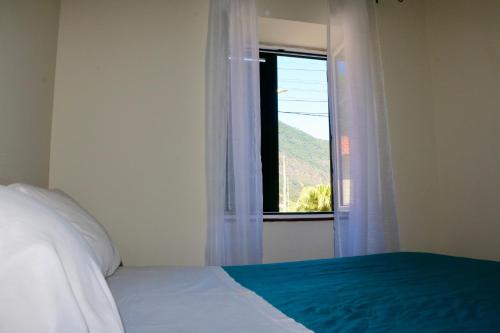 ein Schlafzimmer mit einem Bett und einem Fenster in der Unterkunft Mountain View Villa in São Vicente