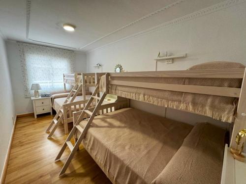 a bedroom with two bunk beds and a desk at Alojamiento Barbastro in Salou