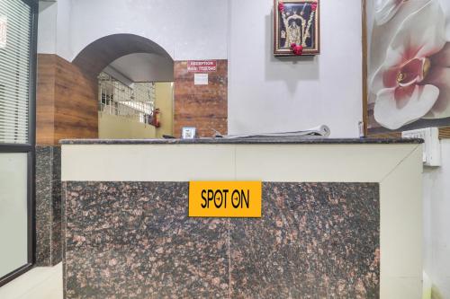 a yellow sign on a counter in a room at SPOT ON New Balaji Residency in Hyderabad