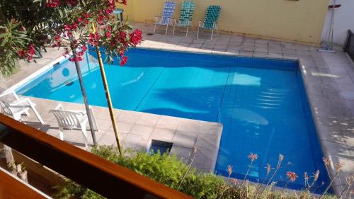Una piscina con agua azul en un patio. en La Maison de Marinés, en Villa Nueva