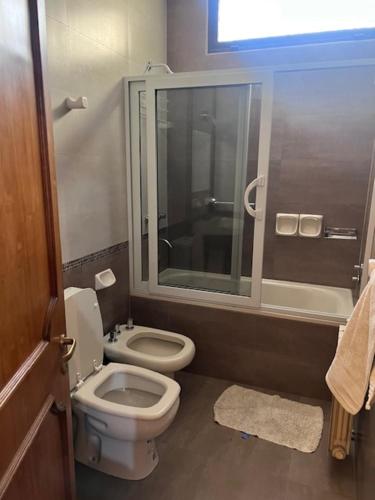 Un baño con inodoro y ducha de cristal. en La Maison de Marinés, en Villa Nueva