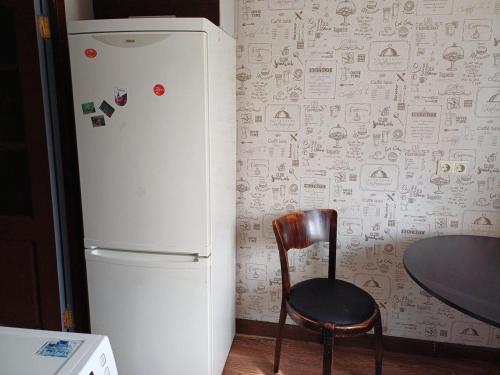 una silla junto a una nevera en la cocina en Inzenieru 77 apartment, en Ventspils