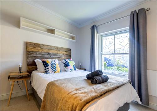 a bedroom with a bed and a window at Pelicans Nest in Onrus in Hermanus
