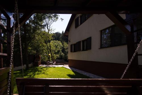 a swing in front of a building with a yard at Cuibul Zăganului - Relax, Sauna & SPA in Cheia