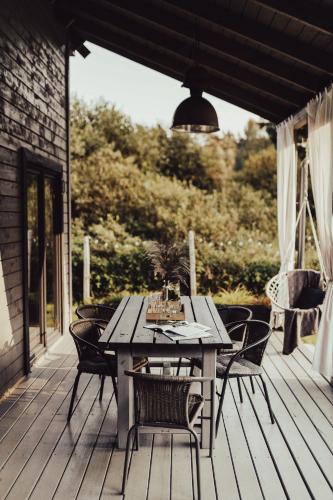 a wooden table and chairs on a deck at Leśny Azyl Marózek in Maróz
