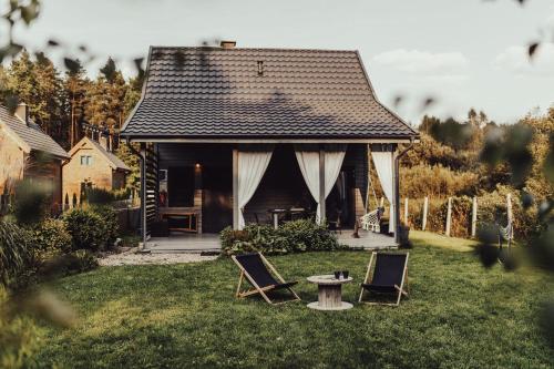 a house with two chairs and a table in the yard at Leśny Azyl Marózek in Maróz