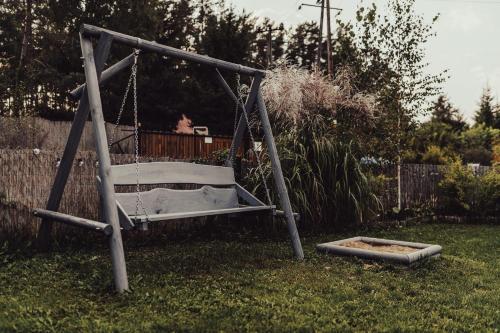 a swing in a yard with a cat on it at Leśny Azyl Marózek in Maróz