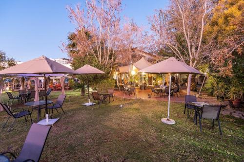 a group of tables and chairs under umbrellas at Auas City Hotel in Windhoek