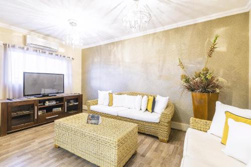 a living room with a couch and a tv at Auas City Hotel in Windhoek