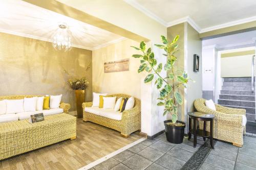 a living room with wicker chairs and a couch at Auas City Hotel in Windhoek