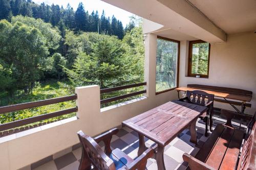 a porch with a wooden table and chairs and a window at Cuibul Zăganului - Relax, Sauna & SPA in Cheia