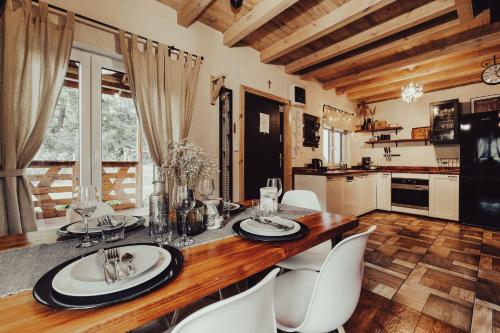 a dining room with a table and white chairs at Leśny Azyl Marózek in Maróz