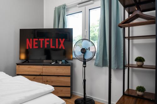 a bedroom with a television with a netflix sign on it at Design Luxus, Vollausstattung, Neubau, 30min Hbf Leipzig 8, Nähe Flughafen, BMW, DHL, Amazon in Schkeuditz