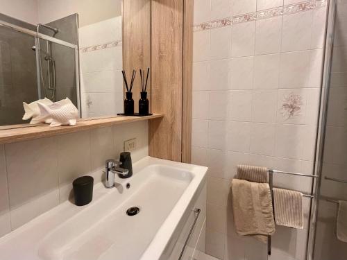 biała łazienka z umywalką i prysznicem w obiekcie L'Acero Home w mieście Baveno