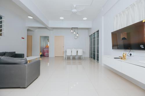 a white living room with a couch and a tv at Kings Pine Residence homestay 14 in Ranau
