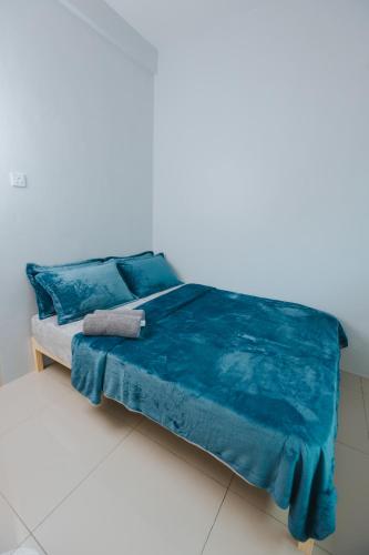 a bed with a blue blanket and pillows on it at Kings Pine Residence homestay 14 in Ranau