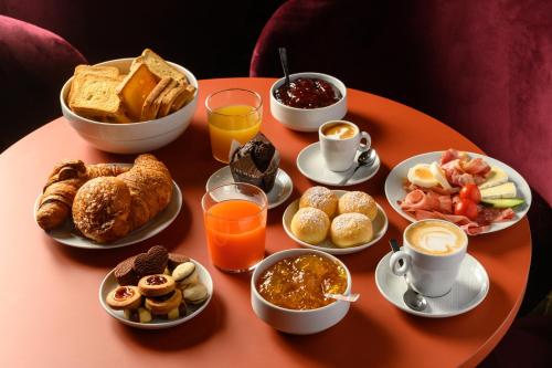 a table topped with plates of breakfast foods and drinks at CX Milan Bicocca in Milan