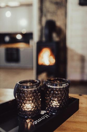two glass jars with lights on a black tray at Leśny Azyl Marózek in Maróz