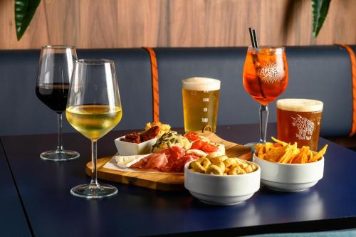 a table with a tray of food and two glasses of wine at CX Milan Bicocca in Milan