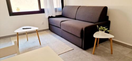 un salon avec un canapé et deux tables dans l'établissement 2 Le Saint Joseph studio in city center of Antibes with AC, à Antibes