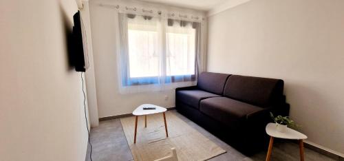 un salon avec un canapé et une fenêtre dans l'établissement 2 Le Saint Joseph studio in city center of Antibes with AC, à Antibes