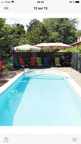 une piscine bleue avec des chaises et des parasols dans l'établissement Grande maison dans les Pyrénées, à Surba