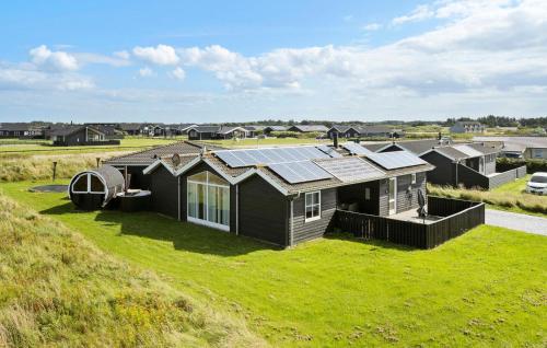 a house with solar panels on top of a green field at Nice Home In Løkken With Kitchen in Løkken