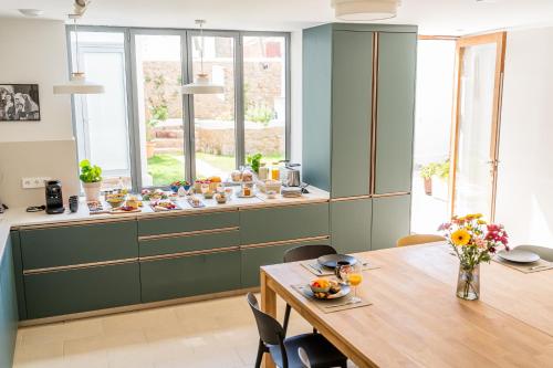 a kitchen with green cabinets and a wooden table at Laguna Cool Living in La Laguna