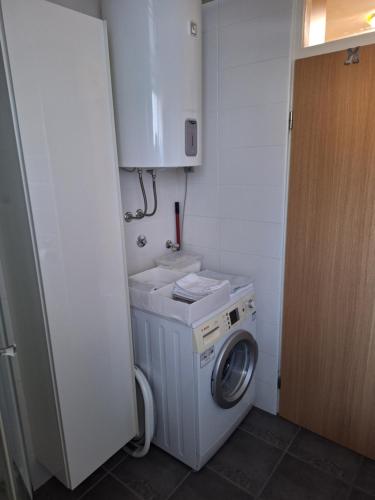 a washer and dryer in a small bathroom at STUDIO APARTMAN MARKo C self-check in,frre parking in Karlovac