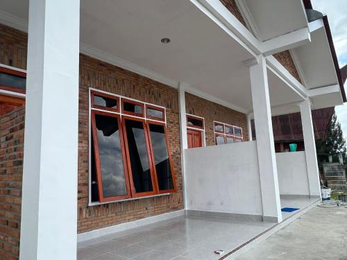 a brick building with a window on the side of it at Hisar Guest House in Tuk Tuk