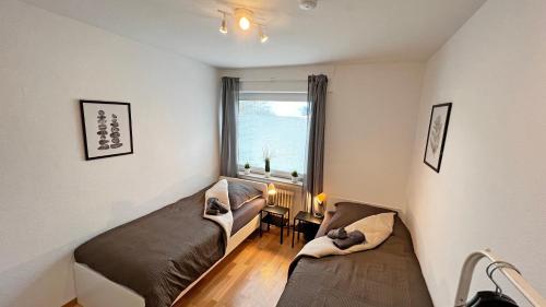 a small room with two beds and a window at Ruhige Monteur Wohnung in Bad Laer