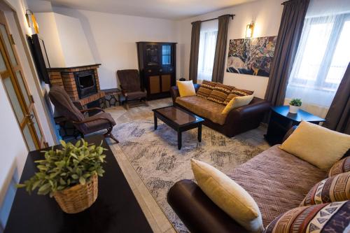 a living room with couches and a fireplace at Cuibul Zăganului - Relax, Sauna & SPA in Cheia
