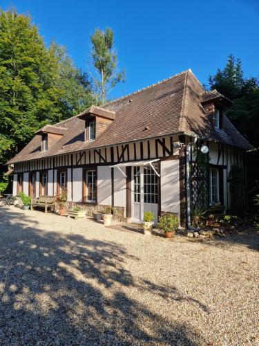 a house with a gambrel roof on a gravel driveway at gîte du moulin de Granchain in Bernay