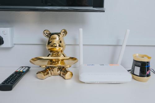 a gold dog statue sitting on a counter next to a remote control at Kings Pine Residence homestay 14 in Ranau