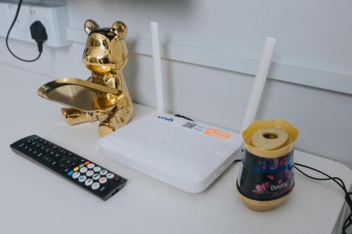 a table topped with a remote control and a drink at Kings Pine Residence homestay 14 in Ranau