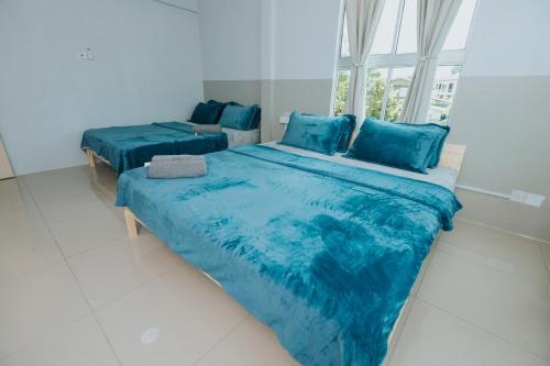 two beds with blue sheets in a room with a window at Kings Pine Residence homestay 14 in Ranau