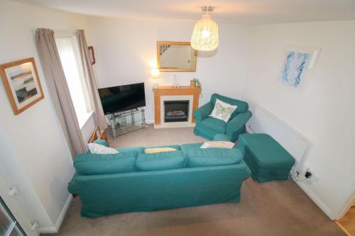 a living room with a blue couch and a television at Beckside Garden Brampton in Brampton