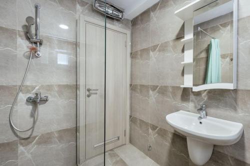 ein Badezimmer mit Waschbecken und Glasdusche in der Unterkunft Luka 17 in Herceg-Novi