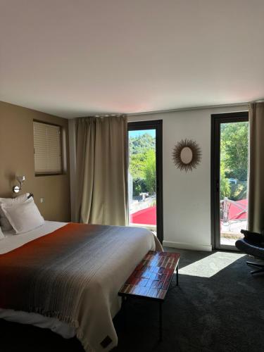 a bedroom with a large bed and a large window at Le Clos Jeannon in Nancy