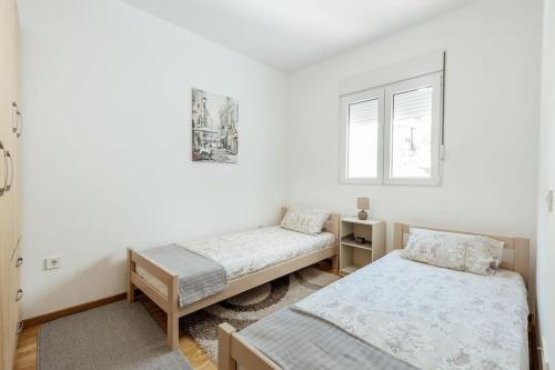 ein Schlafzimmer mit zwei Betten und einem Fenster in der Unterkunft Luka 17 in Herceg-Novi